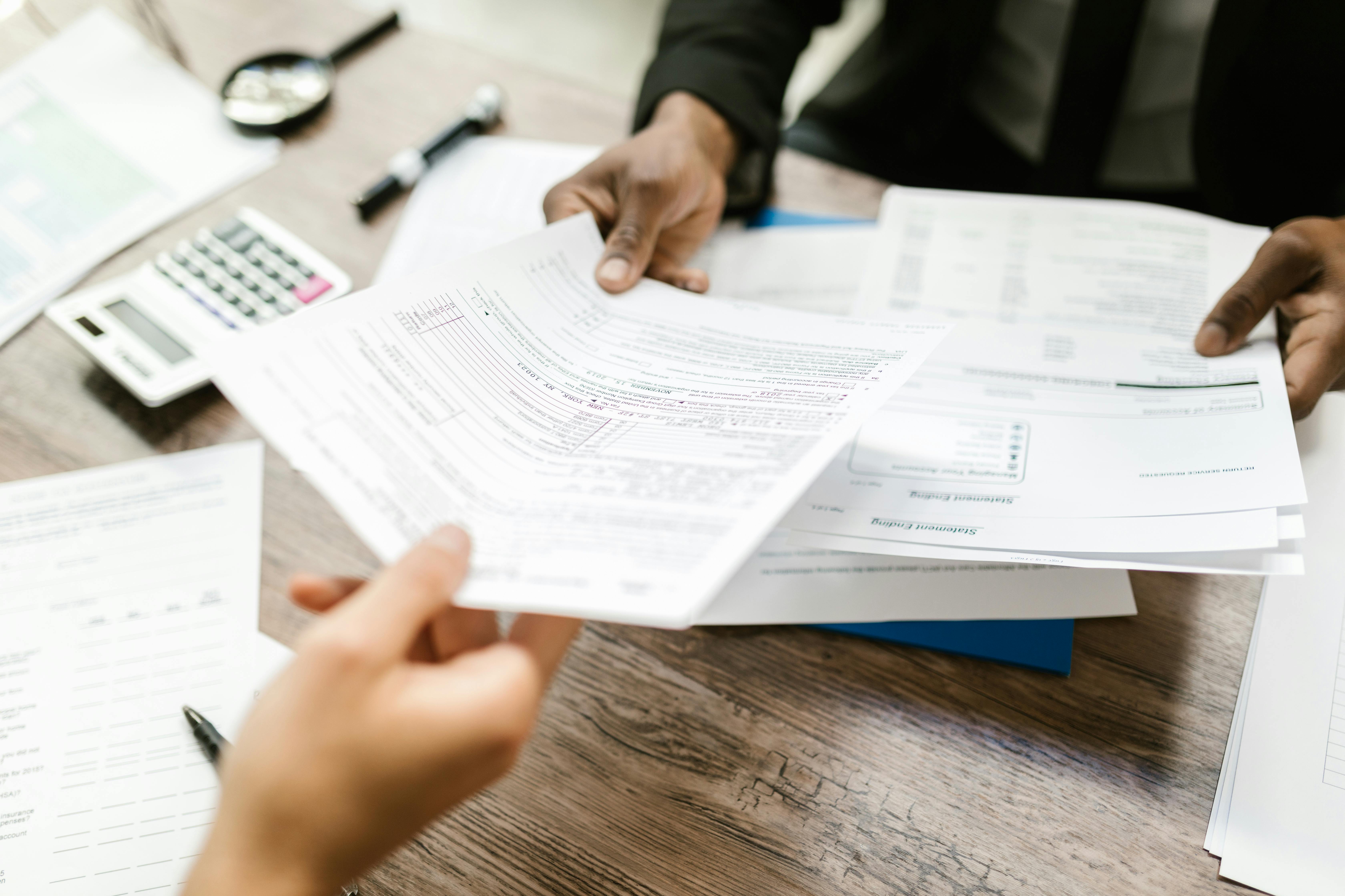 Two people exchanging document Advance Your Accounting Career with an Online Master of Professional Accountancy Hero Image